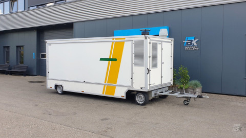 Zijaanzicht van een aanhangwagen voor diverse branches met gesloten luifel