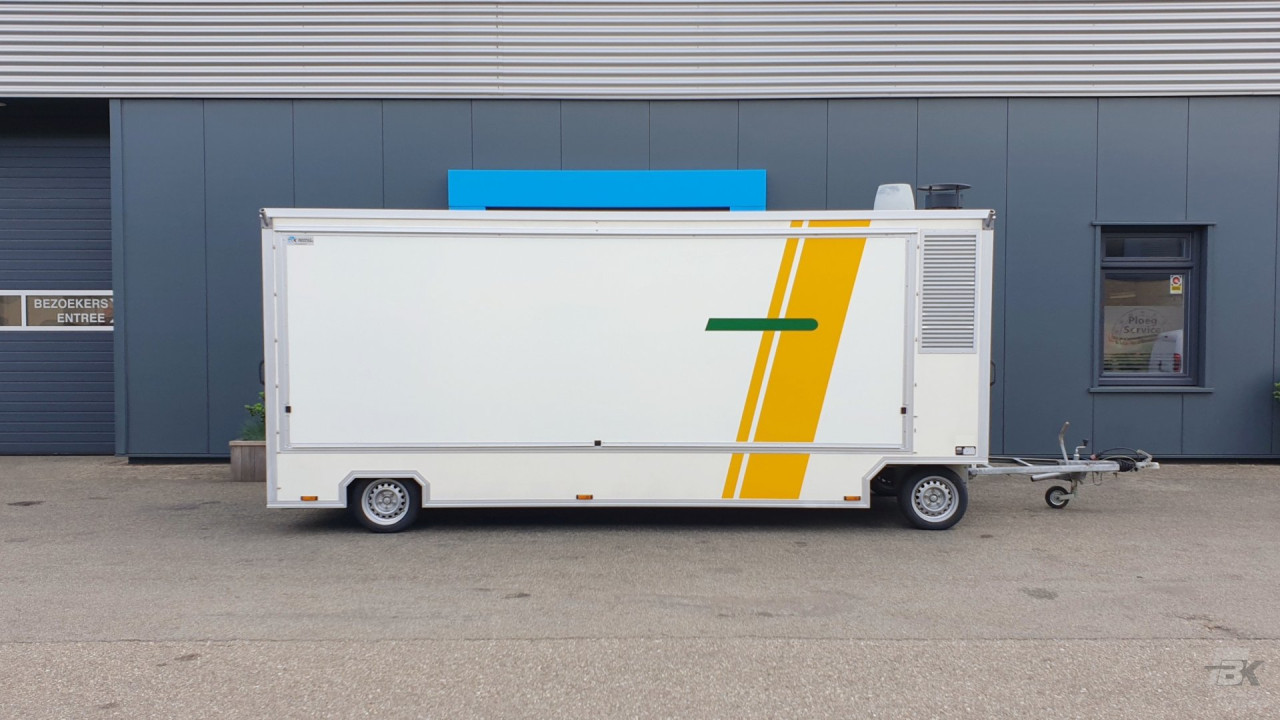 Zijaanzicht van een aanhangwagen voor diverse branches met gesloten luifel