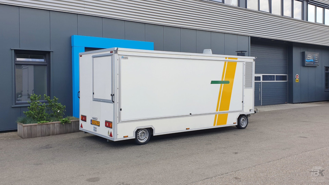 Zijaanzicht van een aanhangwagen voor diverse branches met gesloten luifel
