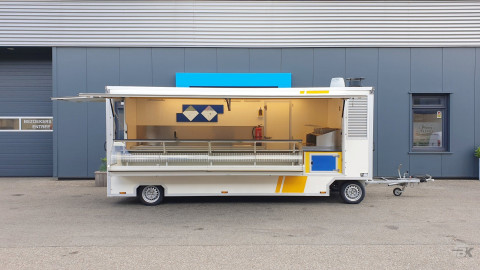 Zijaanzicht van een aanhangwagen voor diverse branches met geopende luifel