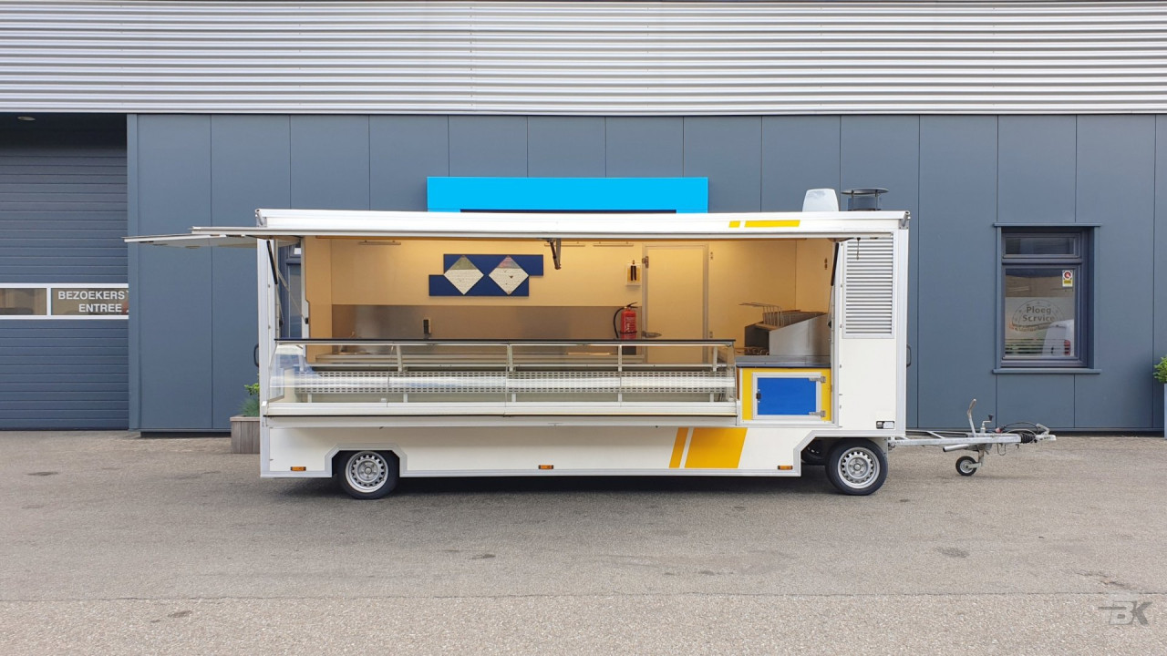 Zijaanzicht van een aanhangwagen voor diverse branches met geopende luifel