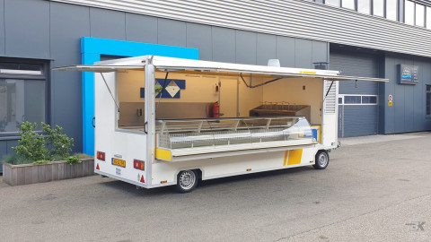 Zijaanzicht van een aanhangwagen voor diverse branches met geopende luifel