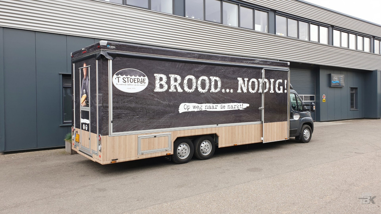 Zijaanzicht van een verkoopwagen voor brood en banket met gesloten luifel