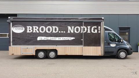Zijaanzicht van een verkoopwagen voor brood en banket met gesloten luifel