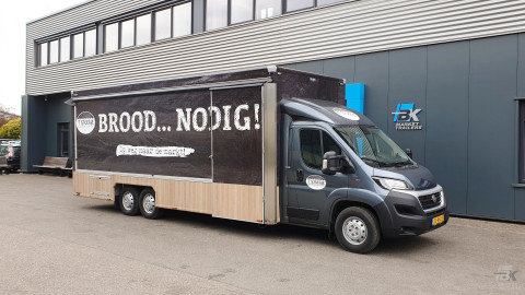 Zijaanzicht van een verkoopwagen voor brood en banket met gesloten luifel