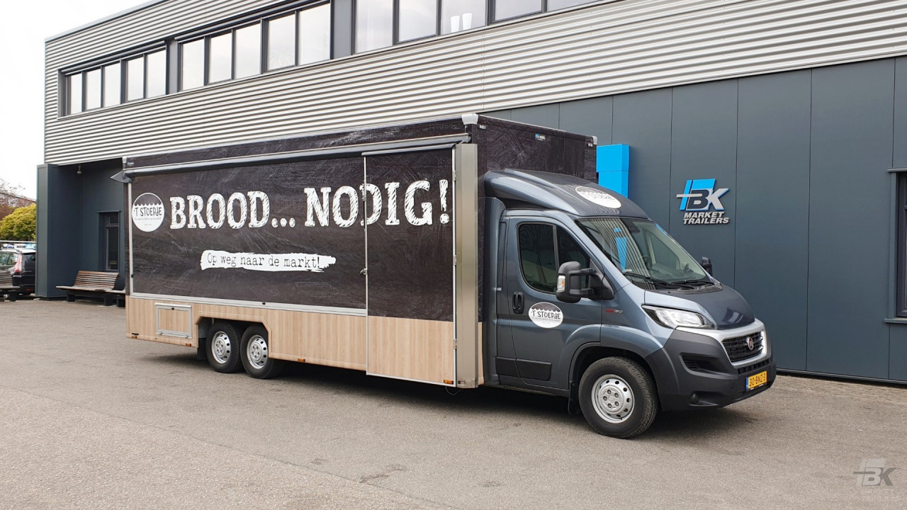 Zijaanzicht van een verkoopwagen voor brood en banket met gesloten luifel