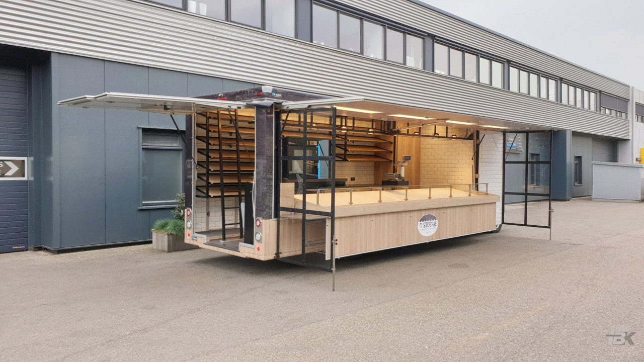 Zijaanzicht van een verkoopwagen voor brood en banket met geopende luifel