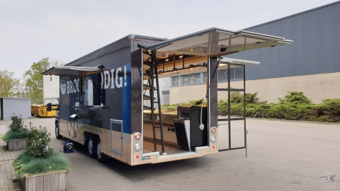 Achterkant van een verkoopwagen voor brood en banket met geopende luifel