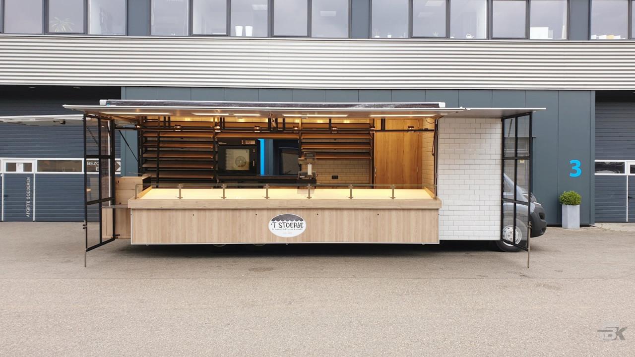 Zijaanzicht van een verkoopwagen voor brood en banket met geopende luifel