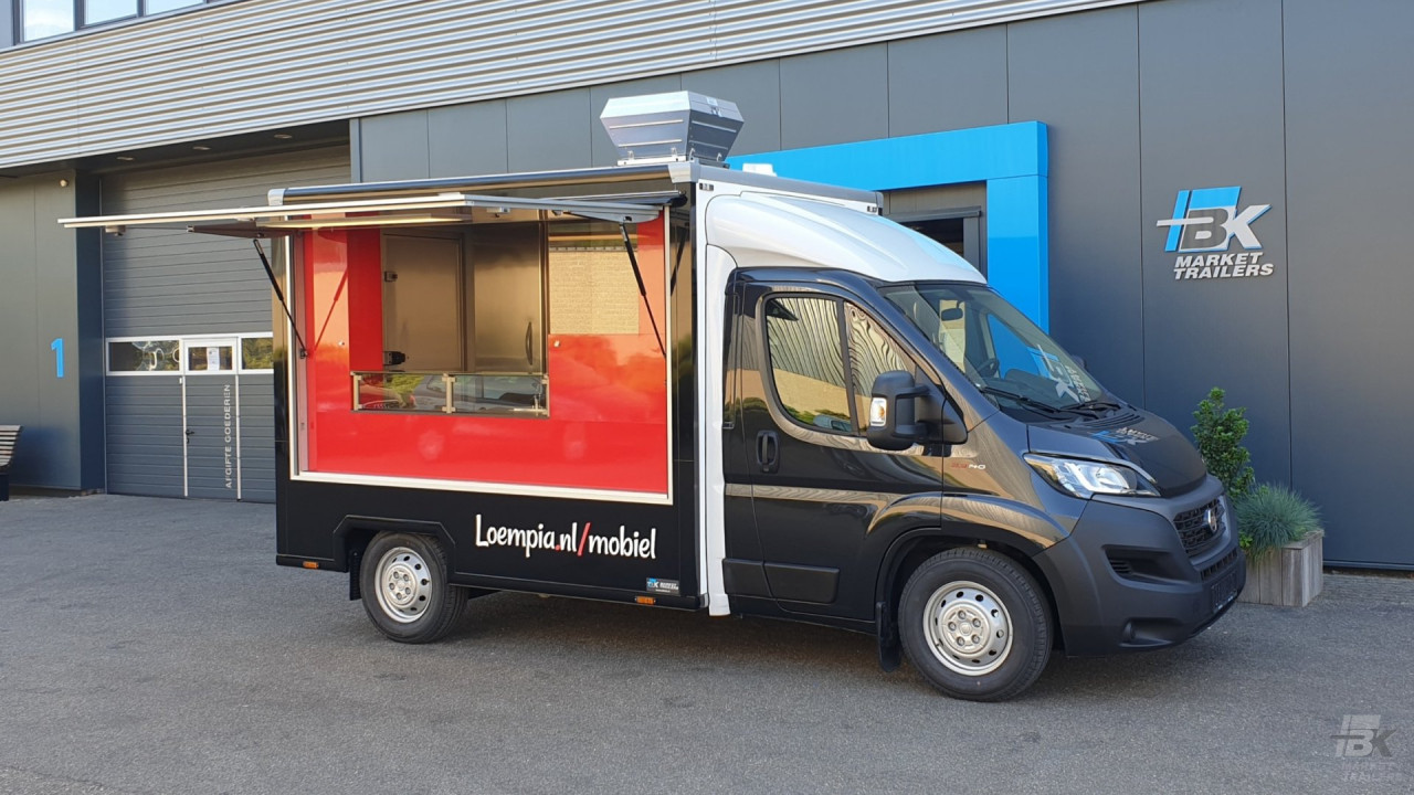 Zijaanzicht van een verkoopwagen voor loempia's met geopende luifel