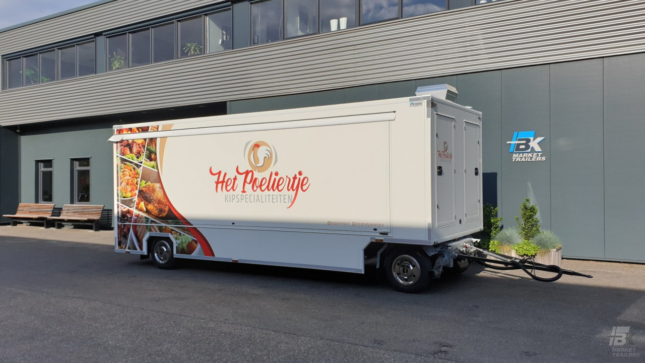 Zijaanzicht van een aanhangwagen voor kipspecialiteiten met gesloten luifel