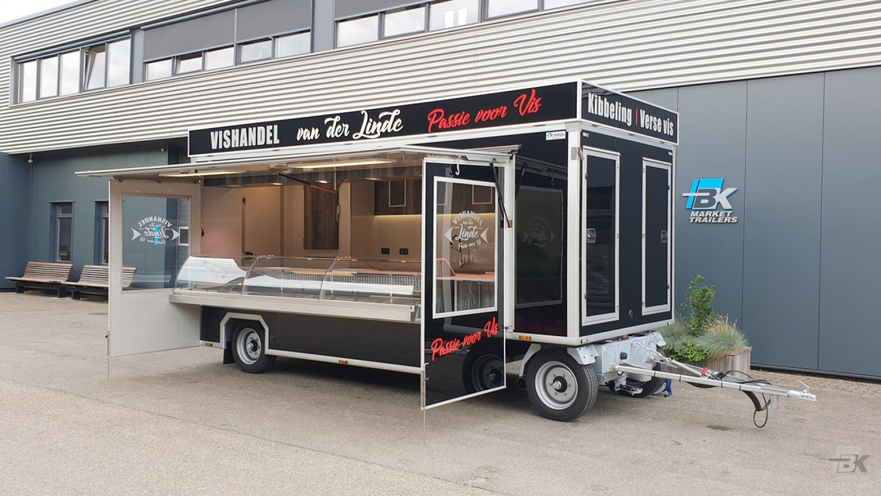 Zijaanzicht van een aanhangwagen voor vis met geopende luifel en zijborden
