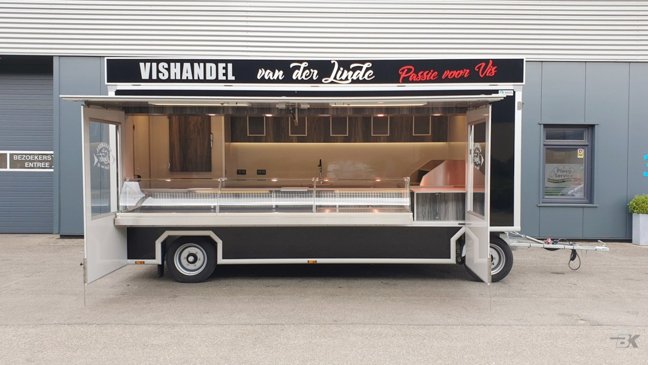 Zijaanzicht van een aanhangwagen voor vis met geopende luifel en zijborden