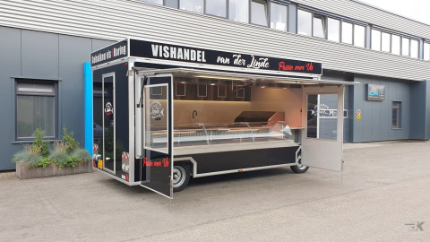 Zijaanzicht van een aanhangwagen voor vis met geopende luifel en zijborden