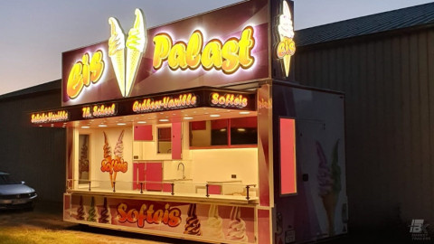 Zijaanzicht van een aanhangwagen voor softijs in het donker met verlichting