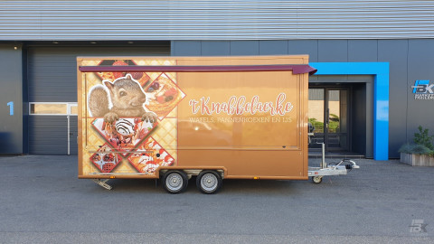Zijaanzicht van een aanhangwagen voor wafels, pannenkoeken en ijs met gesloten luifel