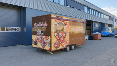 Zijaanzicht van een aanhangwagen voor wafels, pannenkoeken en ijs met gesloten luifel