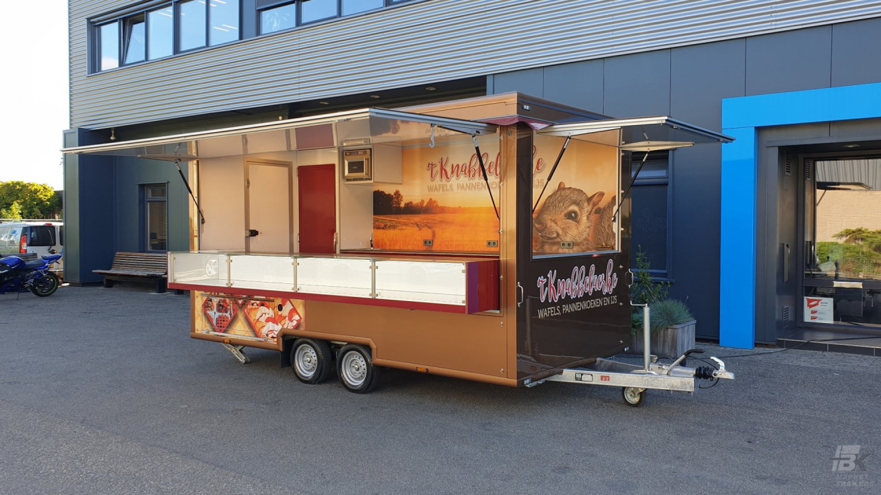 Zijaanzicht van een aanhangwagen voor wafels, pannenkoeken en ijs met geopende luifel
