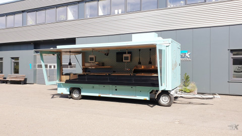 Zijaanzicht van een aanhangwagen voor vis met geopende luifel en zijborden