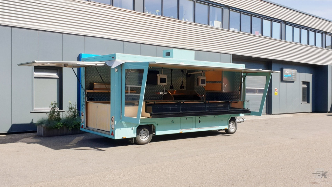 Zijaanzicht van een aanhangwagen voor vis met geopende luifel en zijborden