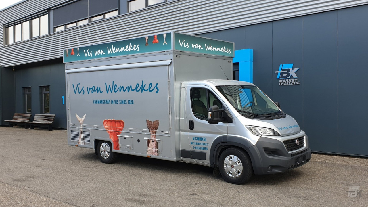 Zijaanzicht van een verkoopwagen voor vis met gesloten luifel