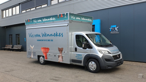 Zijaanzicht van een verkoopwagen voor vis met gesloten luifel