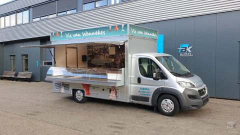 Zijaanzicht van een verkoopwagen voor vis met geopende luifel