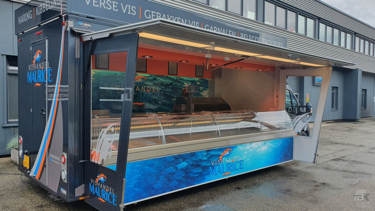 Zijaanzicht van een verkoopwagen voor vis met geopende luifel en zijborden