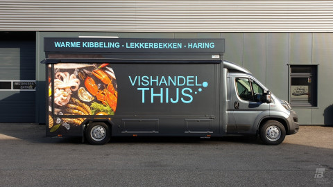 Zijaanzicht van een verkoopwagen voor vis met gesloten luifel