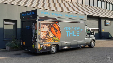 Zijaanzicht van een verkoopwagen voor vis met gesloten luifel