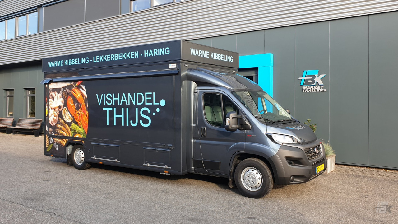 Zijaanzicht van een verkoopwagen voor vis met gesloten luifel