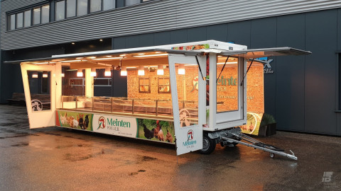Zijaanzicht van een smalle aanhangwagen voor kip met geopende luifel en zijborden
