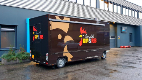 Zijaanzicht van een aanhangwagen voor kip aan het spit met gesloten luifel