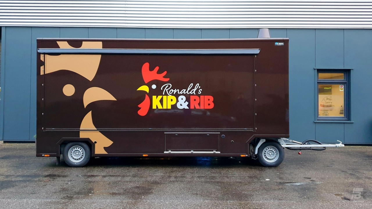 Zijaanzicht van een aanhangwagen voor kip aan het spit met gesloten luifel