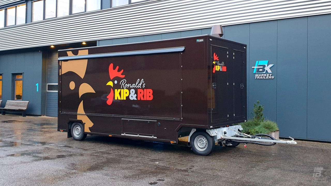 Zijaanzicht van een aanhangwagen voor kip aan het spit met gesloten luifel