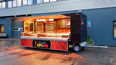 Zijaanzicht van een aanhangwagen voor kip aan het spit met geopende luifel