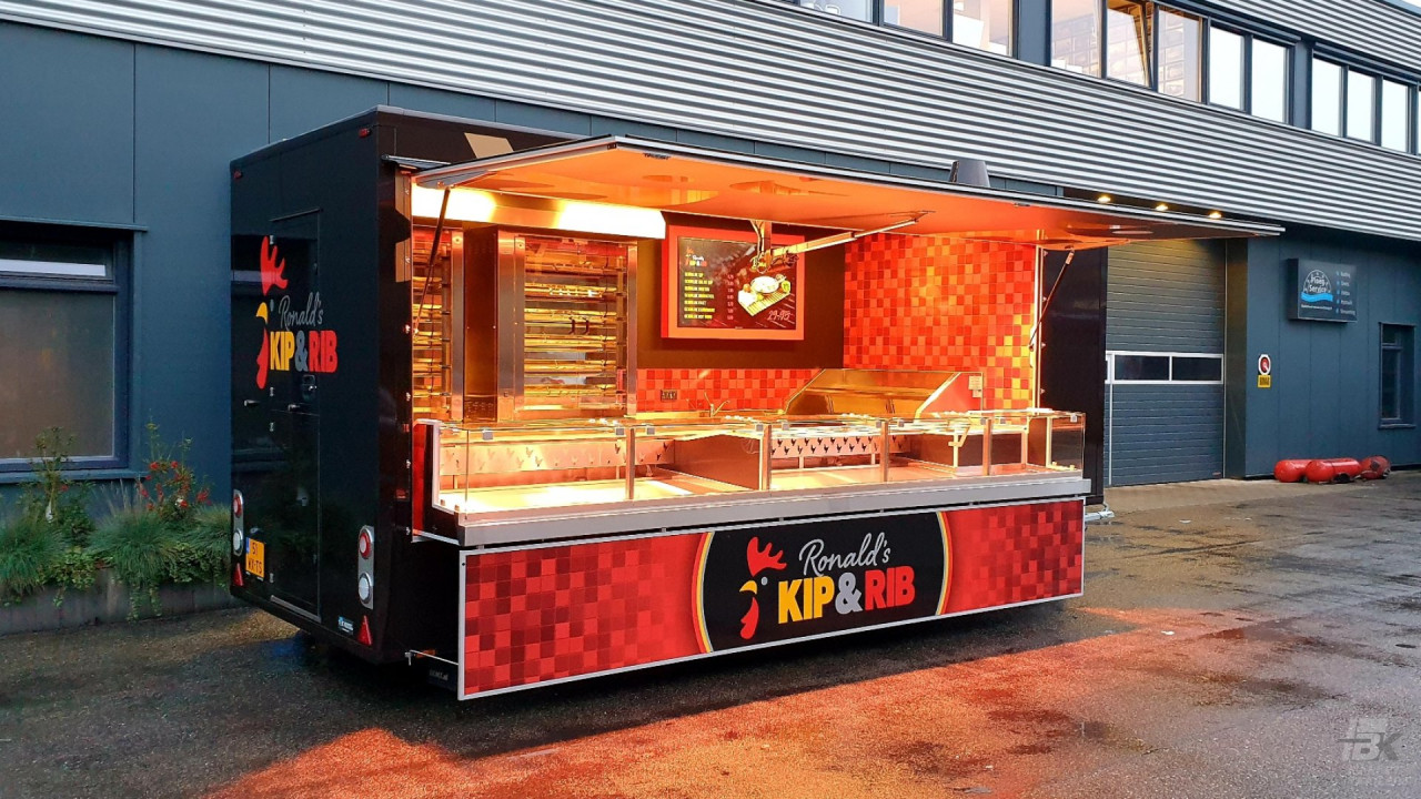 Zijaanzicht van een aanhangwagen voor kip aan het spit met geopende luifel