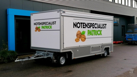 Zijaanzicht van een aanhangwagen voor noten met gesloten luifel