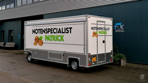 Zijaanzicht van een aanhangwagen voor noten met gesloten luifel