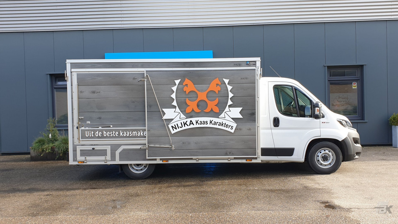 Zijaanzicht van een verkoopwagen voor kaas met gesloten luifel