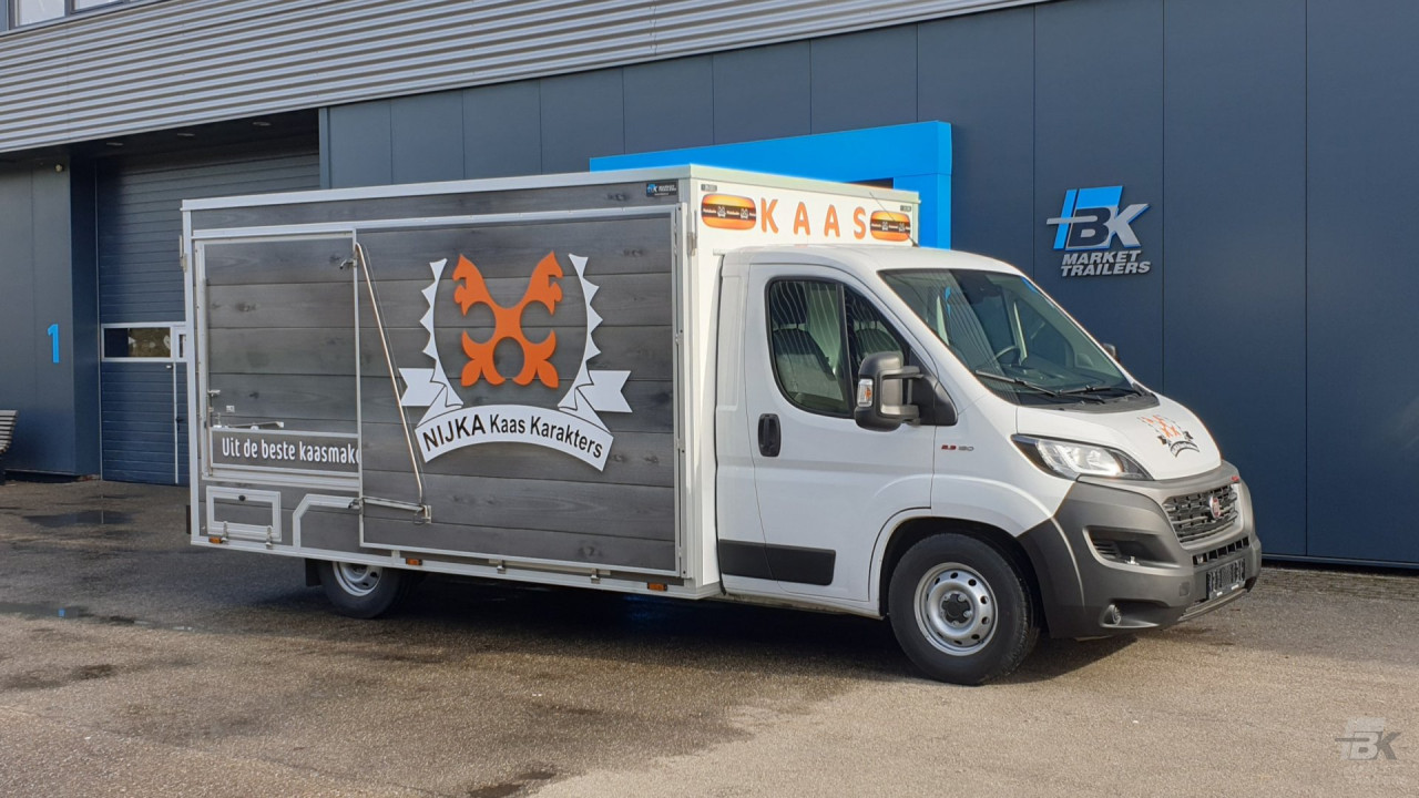 Zijaanzicht van een verkoopwagen voor kaas met gesloten luifel