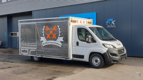 Zijaanzicht van een verkoopwagen voor kaas met gesloten luifel
