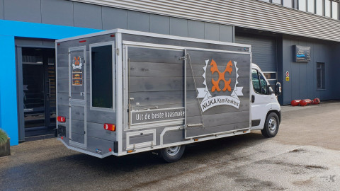 Zijaanzicht van een verkoopwagen voor kaas met gesloten luifel