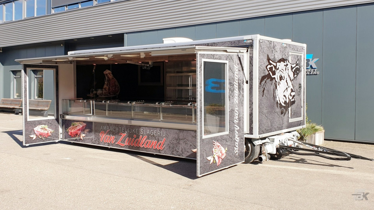 Zijaanzicht van een aanhangwagen voor vlees met geopende luifel en tochtborden