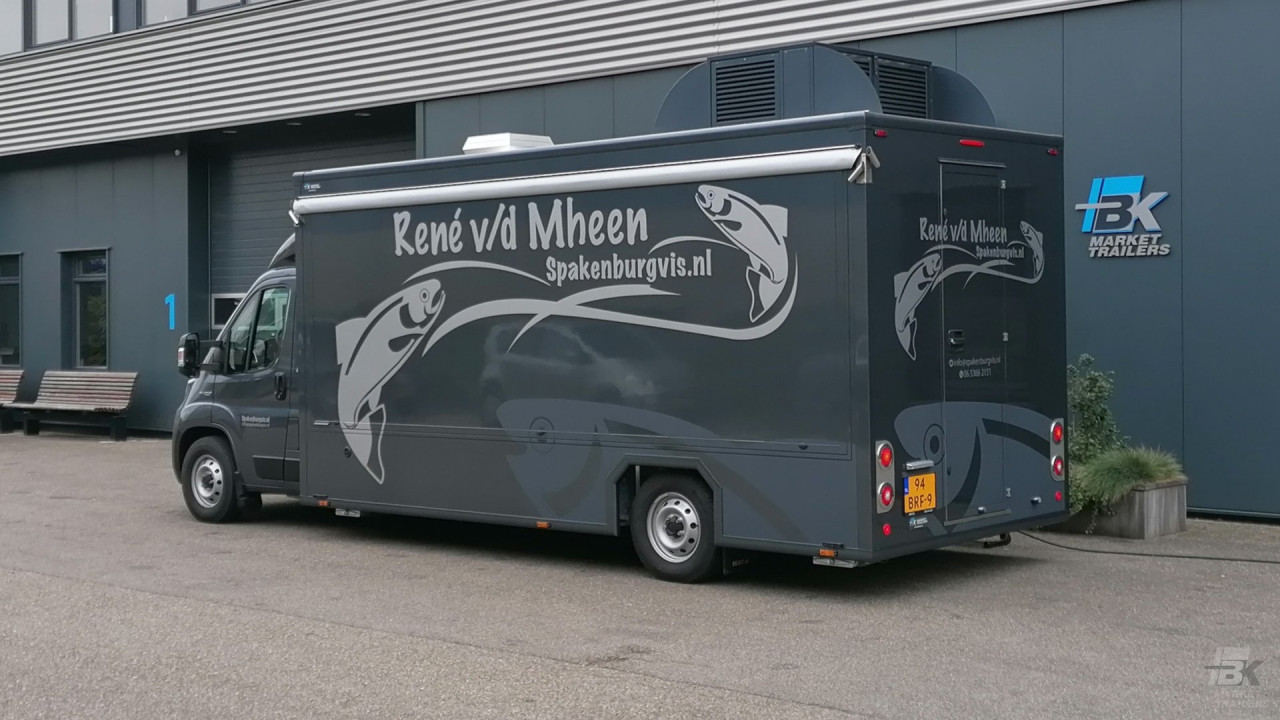 Zijaanzicht van een verkoopwagen voor vis met gesloten luifel