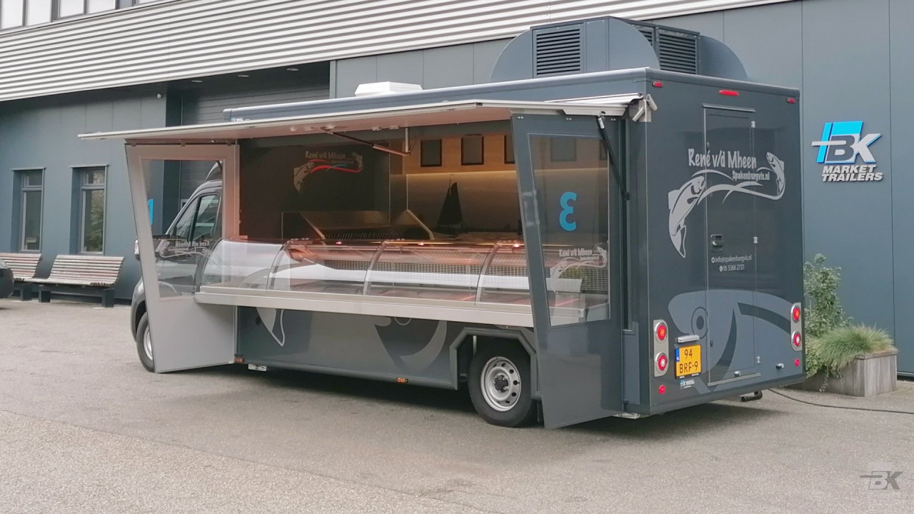 Zijaanzicht van een verkoopwagen voor vis met geopende luifel en zijborden