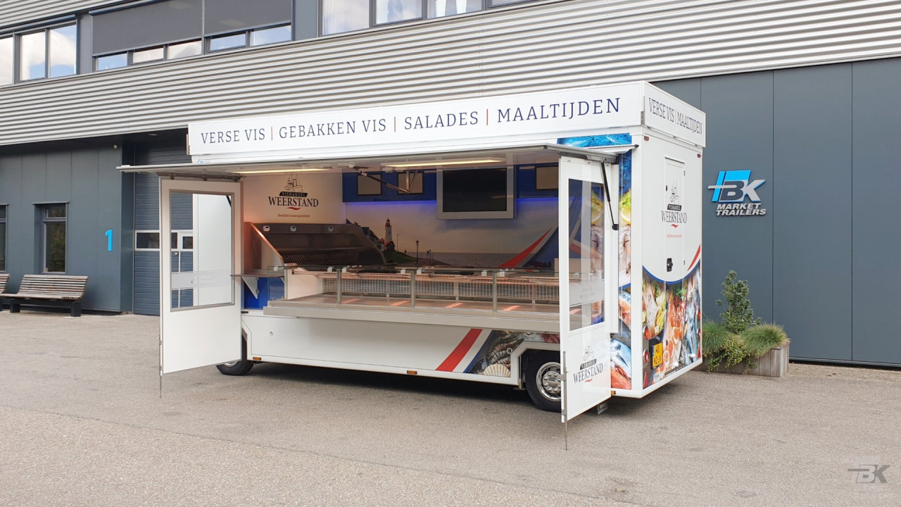 Zijaanzicht van een aanhangwagen voor vis met geopende luifel en zijborden