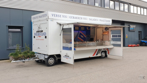 Zijaanzicht van een aanhangwagen voor vis met geopende luifel en zijborden