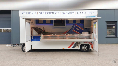 Zijaanzicht van een aanhangwagen voor vis met geopende luifel en zijborden