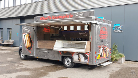 Zijaanzicht van een verkoopwagen voor loempia's met geopende luifel